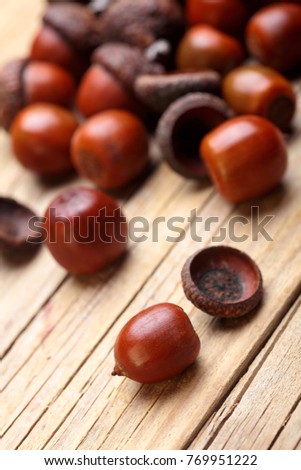 Dried acorn scattered on wooden table.Autumn background.Closeup.Copy space.Selective focus