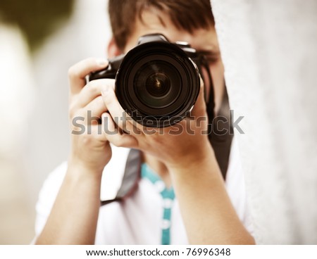 Photographer, selective focus point on nearest part of lens