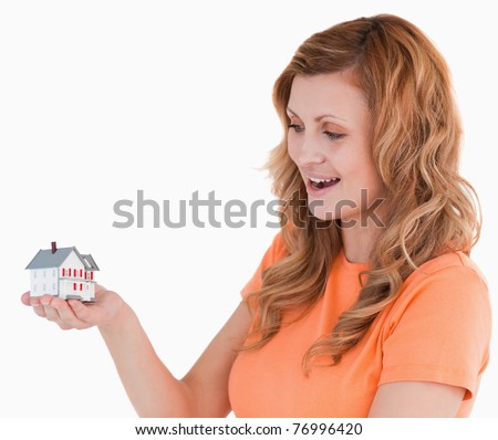 Young woman holding an house model on a white background