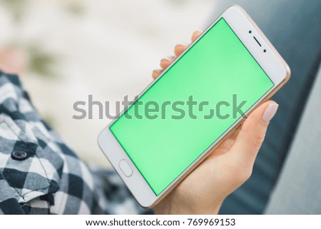 Beautiful girl holding a smartphone in the hands of a green screen green screen, hand of man holding mobile smart phone with chroma key green screen on white background, new technology concept