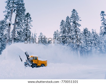 Tractor is best for snow plowing (snow removal). California winter, Mammoth ski resort. Plowing deep snow Royalty-Free Stock Photo #770051101