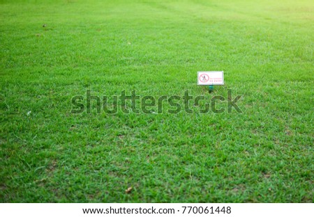 The sign on the label  with words"No ENTRY" on a green lawn.