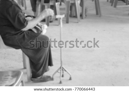 Elderly woman on wheelchair covered with blanket blur black and white picture.