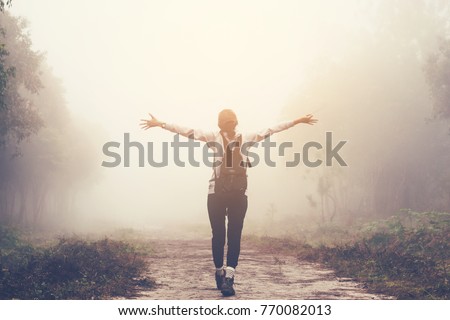 traveller women walking on road in the forest paths in the woods and foggy, hiker women enjoying the beautiful nature with fog.
 Royalty-Free Stock Photo #770082013