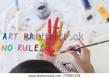 Education , Art and creativity learning concept - student painting her hands with acrylic color