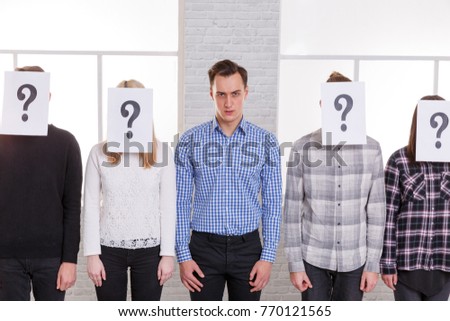 A group of people with sheets with question marks on their faces other than a guy