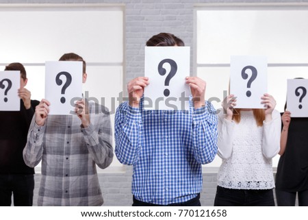 Groups of people covered their faces with a question mark close-up
