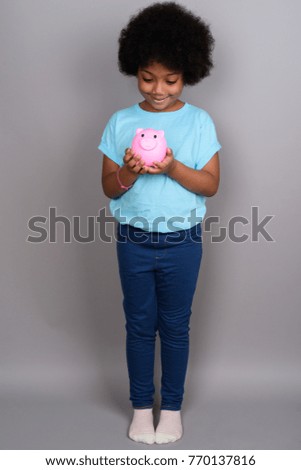 Studio shot of young cute African girl against gray background