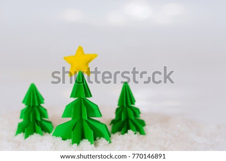 miniature paper pine tree figures with felted star on the top and red gift boxes, selective focus