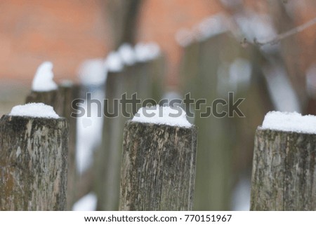 snow on a wooden fence