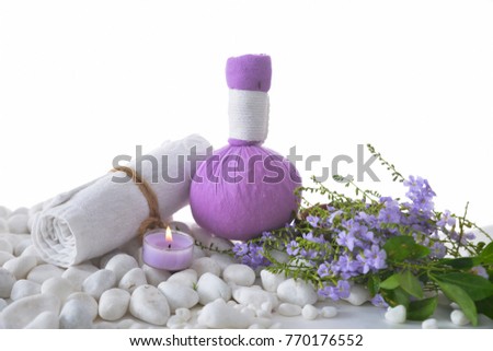 Tropical flower with herbal ball ,towel, on pile of white stones
