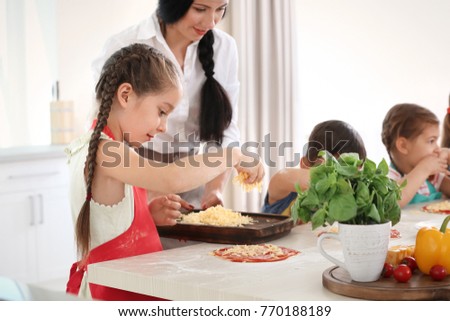 Children and teacher in kitchen during cooking classes