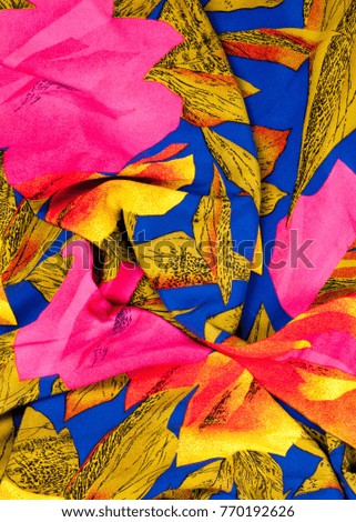 The texture of the silk fabric, red and yellow flowers on a blue background