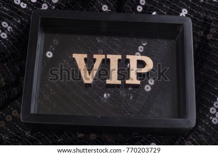 VIP is written in abstract letters in a black frame. Black luxurious sparkling background