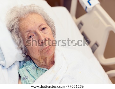 Elderly 80 year old woman with Alzheimer's disease in a hospital bed. Royalty-Free Stock Photo #77021236