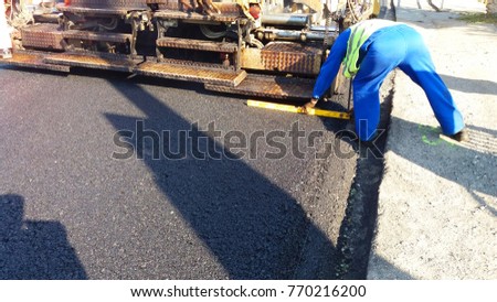 Hot Asphalt being laid and measured for a quality check as a part of a on site control test.