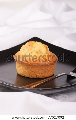 Homemade muffin served on a black plate.