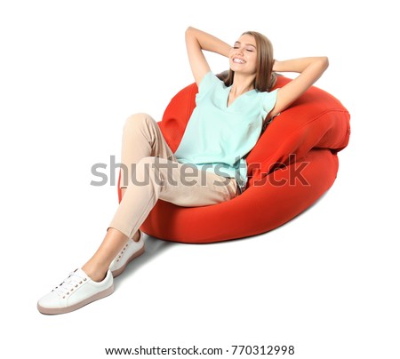 Happy young woman relaxing on lounge against white background