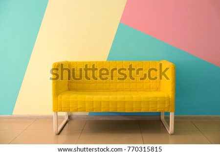 Comfortable armchair near color wall Royalty-Free Stock Photo #770315815