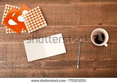 Office desk table. Top view with blank greeting card, pencil and coffee on wooden table background. Top view with copy space