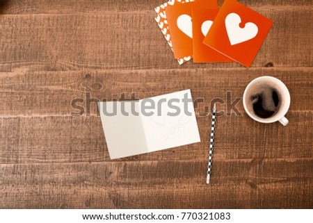 Office desk table. Top view with blank greeting card, pencil and coffee on wooden table background. Top view with copy space