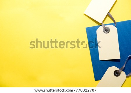 yellow background decorate with paper price tags and blue card.flat lay, top view