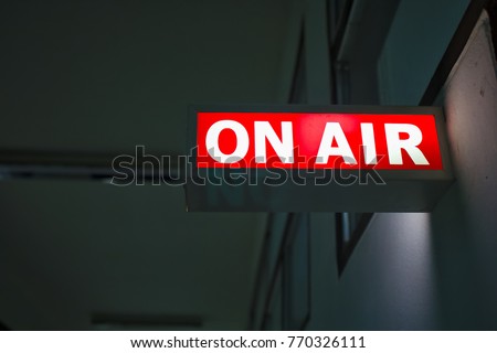 On air glowing sign over the door in front of the office. Live tv or radio light. Live tv and radio broadcast channel concept. Royalty-Free Stock Photo #770326111