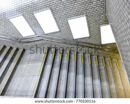 Stairs in the train station with white label on the wall for inserting pictures and text.
