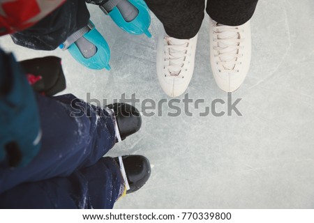 mother and kids skating together in winter