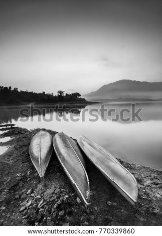 Fine art image in black & white of kayaks at misty lake Beris, Malaysia. Soft Focus due to long exposure.