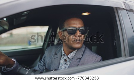 Paparazzi man sitting inside car and photographing with dslr camera