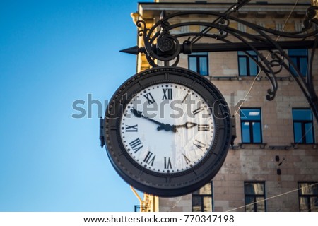 The vintage city clock in the street on a warm sunny day.