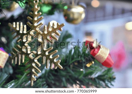 Close up Golden Christmas snow symbol decorated on green Christmas tree for celebration in Christmas festival and New Year 