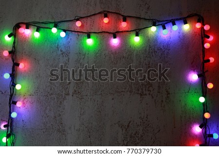 Christmas lights hang on the old wall. Place for text