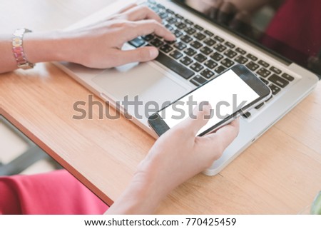 Woman relaxing while using smartphone blank screen for graphics display montage.Over the shoulder view of