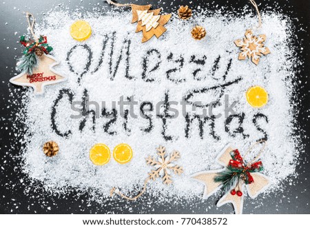 Christmas background with the inscription Merry Christmas on white snow with wooden toys, lemon, snowflakes and New Year decor. Winter Holiday