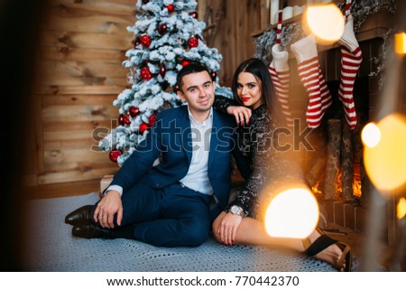 A guy with a girl is celebrating Christmas. A loving couple enjoys each other on New Year's Eve in a cozy home environment. 