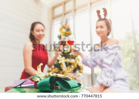 Gift Box and Happy beautiful Asian woman with clinking glasses of champagne or wine in hands on celebration party. Holiday or Christmas or Birthday or New Year eve concept