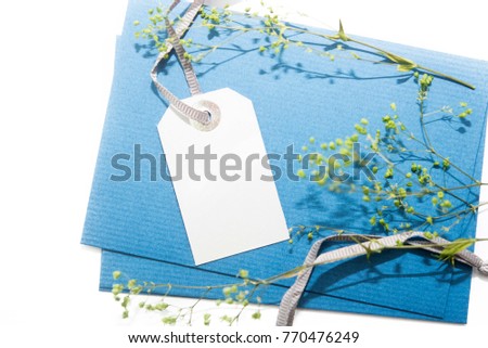 paper price tags on blue recycle paper with tree branches. flat lay, top view