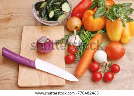 Fresh vegetables for salad and ceramic knife on kitchen board. The quality of medium format