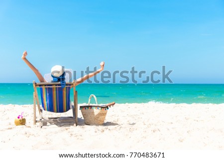 Summertime Vacation. Young girl asian woman relaxing and happy outdoors beach chair out with cocktail coconut juice in holiday summer blue sky background.  Travel and lifestyle Concept Royalty-Free Stock Photo #770483671