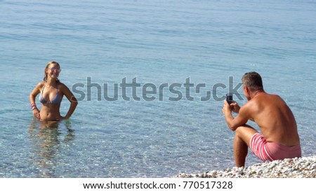 Man taking photo a woman on beautiful paradise  beach.