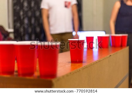 Game in beer pong. Red cups, ball. Happy, friends, beer, drink.