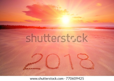2018 inscription on wet sandy beach after ebb. Concept of celebrating the New Year.