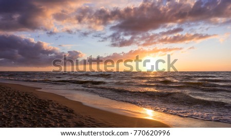 A beautiful sunset on a vast, sandy beach.