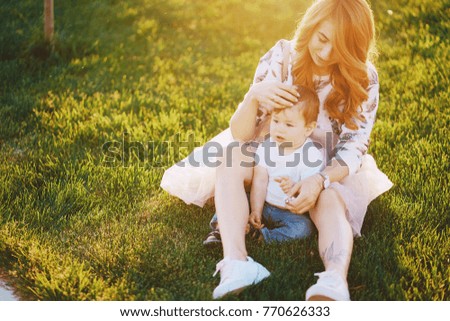 Beautiful red-haired woman with her wonderful son on a summer park