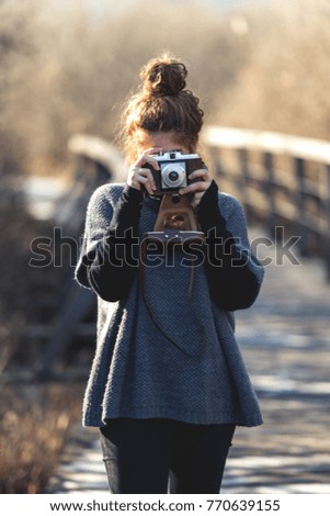 Young girl with an old retro camera photographing 