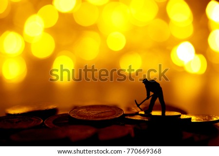 silhouette of Miniature people : worker digging on  coins with bokeh background.Money, Financial, Business Growth concept.