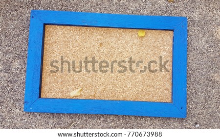 Blue wooden frame for text on sand wash surface background.
