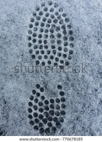 Winter weather, snow on the road with imprints of shoes footprints